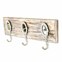 three metal hooks are attached to a wooden coat rack with two mirrors on each hook