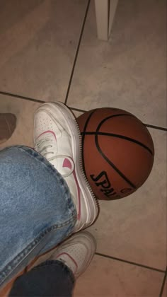 a person standing next to a basketball on the floor