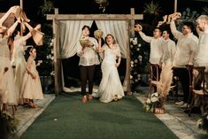 a bride and groom standing in front of a group of people