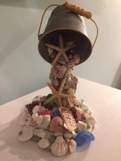 a lamp that is sitting on top of a pile of seashells and starfish