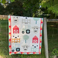 a quilt hanging on a fence in the grass