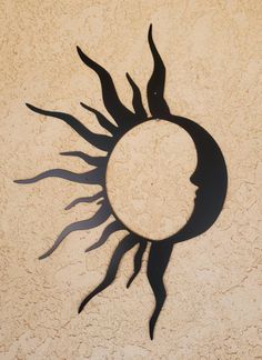 the sun is casting a shadow on the wall with it's face in the center