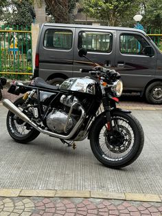 a black motorcycle parked in front of a van