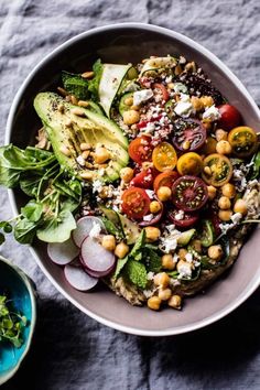 a bowl filled with salad and vegetables on top of a table