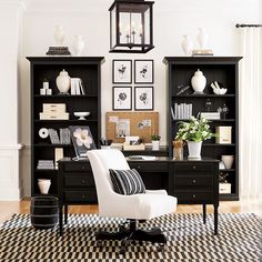 a black and white home office with lots of bookshelves, chairs, and pictures on the wall