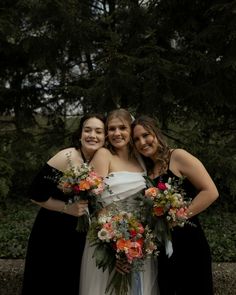 three bridesmaids pose for a photo with their bouquets