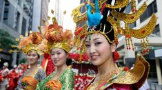 women in colorful costumes are walking down the street