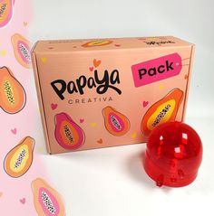 a pink box with papaya on it next to a red ball