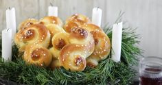 some breads are sitting in a bowl with candles