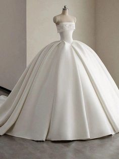 a white ball gown on display in a room with a mannequin dummyt