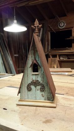 a wooden table topped with a green bird house