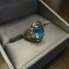 Vintage 14KT Yellow Gold Ring is gorgeous. Three Plus CT Large Oval Blue Topaz Ring with Three Nice Size Genuine Diamonds on One Side of Band. The Gold Band has a Double Swirl on One Side and this Ring is a Size 5. Ring is Hallmarked inside of Band 14K with Maker's Mark. Three Oval Diamonds and they are a nice size. In excellent vintage condition. FREE SHIPPING. FREE SHIPPING - GIFT WRAPPED PERFECT - 10% OFF AT CHECKOUT. I HAVE NOT SEEN A MORE BEAUTIFUL RING AT A VERY VERY VERY GREAT PRICE. Heirloom Blue Topaz Ring With Center Stone, Formal Turquoise Rings With Gemstone Accents, Fine Jewelry Topaz Ring With Gemstone Accents For Anniversary, Oval Topaz Ring With Diamond And Gemstone Accents, Formal Topaz Ring With Gemstone Accents, Fine Jewelry Blue Topaz Birthstone Ring With Gemstone Accents, Oval Blue Topaz Ring With Diamond Accents, Fine Jewelry Topaz Gemstone Rings, Fine Jewelry Topaz Gemstones With Gemstone Accents