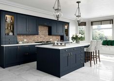 a large kitchen with dark blue cabinets and white counter tops is pictured in this image