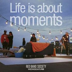 an advertisement for red band society with people standing around the couch and lights strung across the roof