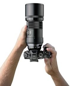 a person holding up a large camera lens