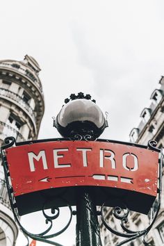 a red metro sign hanging off the side of a pole