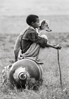 a man sitting on top of a barrel next to a dog