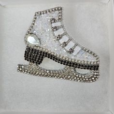 a pair of white and black high top sneakers with crystal stones on the soles