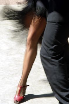 the legs and feet of a woman in high heels are seen from behind, while she is walking