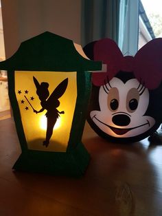 two mickey mouse lanterns sitting on top of a wooden table