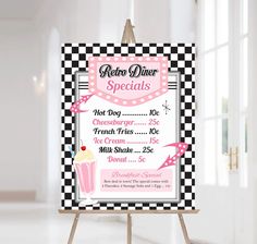 a pink and black checkerboard sign with a cupcake on it's side