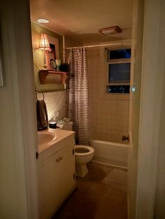 a bathroom with a sink, toilet and bathtub is shown in this image from the doorway