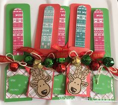 three tags with christmas decorations on them are sitting next to each other and tied together