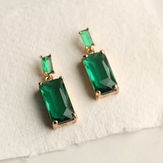 These great earrings are brass and feature a simple and classic rectangular baguette design.  The tiny cubic zirconia jewels are cut into perfect rectangles.  The baguette cut stones are glass in a beautiful, cool toned emerald green shade.   The earrings measure 30mm (just over an inch) in length and have gold plated ear wires.   This piece of handmade jewellery comes packaged in a nice recycled gift box with a handmade tag, all ready to give or keep. 🖤 FASTER SHIPPING 🖤 Need this fast? We offer a Faster Shipping option here: https://www.etsy.com/uk/listing/100107311/faster-shipping-priority-post-upgrade Please read the description before purchasing this listing, as we are unable to post every day! 🖤 GIFT MESSAGE & WRAP SERVICE! 🖤 For those of you who are sending gifts straight to you Formal Rectangular Earrings With May Birthstone, Emerald Rectangular Earrings For May Birthstone, Classic Rectangular Party Earrings, Elegant Rectangular Emerald Earrings For May Birthstone, Elegant Rectangular May Birthstone Earrings, Classic Green Earrings For Party, Elegant Green Rectangular Earrings, Green Rectangular Earrings For Formal Occasions, Green Rectangular Jewelry For Party