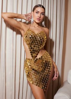 a woman in a gold sequin bodysuit posing for the camera with her hands on her hips