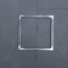 a square metal frame sitting on top of a stone floor