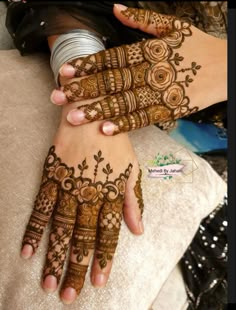 two hands with henna tattoos on them