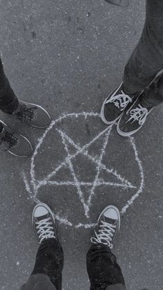 three people standing in the middle of a circle with an inverted pen drawn on it