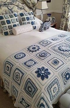 a bed with blue and white crocheted bedspread