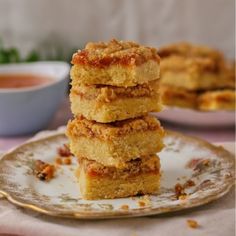 three pieces of cake sitting on top of a plate next to a bowl of sauce