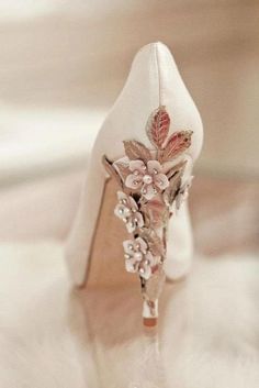 a white high heeled shoe with flowers on it