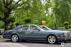 a grey car parked in front of some trees