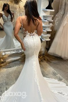 a woman is looking at her wedding dress