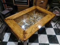 a glass table with antlers in it on a checkered floor