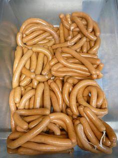 several large links of hot dogs in a container