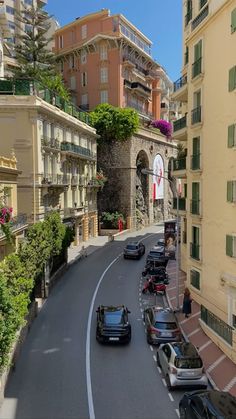 cars are parked on the side of an empty street in front of tall buildings with balconies