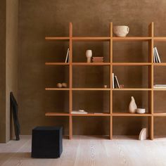 an empty room with bookshelves and vases on the shelves in front of it