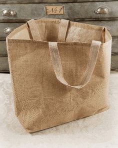 a jute bag sitting on top of a table next to an old dresser drawer