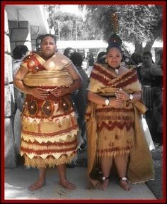 two people standing next to each other in native clothing