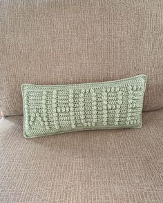 a crocheted pillow sitting on top of a couch