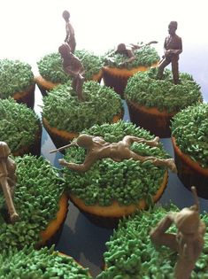 cupcakes decorated with green frosting and figurines in the shape of people