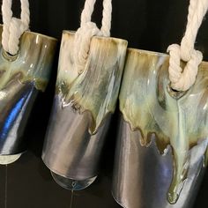 three metal buckets with ropes hanging from them