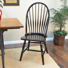 a wooden chair sitting next to a table with a potted plant on top of it