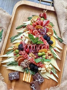 a platter filled with assorted fruits and veggies on top of a wooden tray