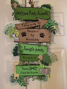 an animal themed birthday party sign hanging from a door handle with jungle animals on it