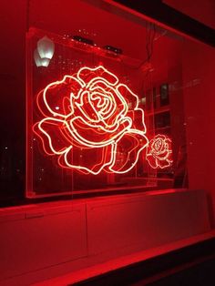 a neon sign with a rose on it